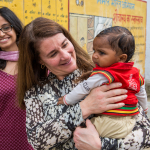 Melinda holds baby after discussing family planning with a group of women